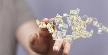 A hand selecting from a 3D render of floating dollar banknotesの写真素材