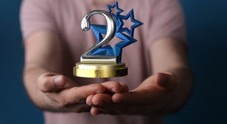 A 3D rendering of a 2nd place trophy with a real person in the backgroundの写真素材
