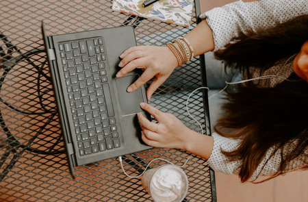 A top view of a South Asian young woman working with the computer in the cafeの写真素材