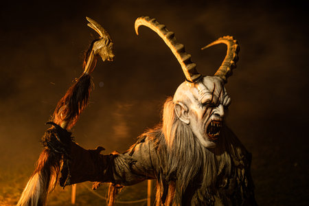 A closeup shot of a person in a Beltane festival costume with horns and a cane