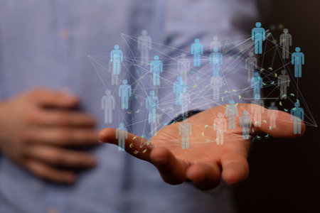 A 3D rendering of people silhouettes in the network team with a real person holding it - digital network conceptの写真素材