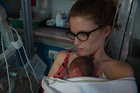 A closeup shot of a mother holds her two days old premature son