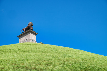 The Lion of Waterloo or Lion's Mound in Belgium on the green hill against a clear blue sky