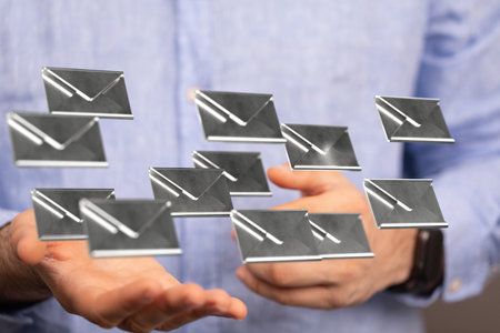 The 3D rendered silver envelopes above the hand of a maleの写真素材