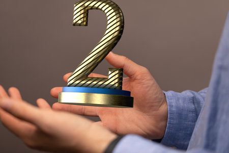 An illustration of a second-place trophy or two years anniversary concept in handsの写真素材