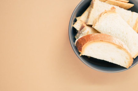 A top view of bread slices on a bowl isolated on brown backgroundの写真素材