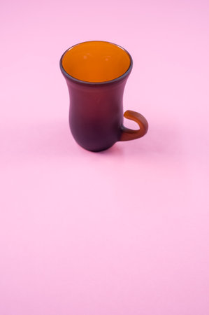 A vertical shot of brown bell-shaped mug isolated on pink backgroundの写真素材
