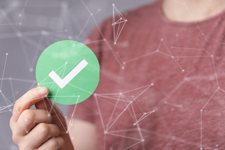A person holding a green checkmark signの写真素材