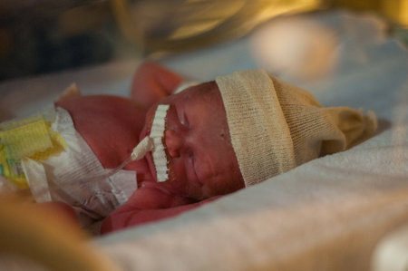A closeup shot of a newborn baby in a hospital bed