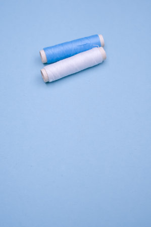 A vertical closeup of threads on the aesthetic blue background.の写真素材