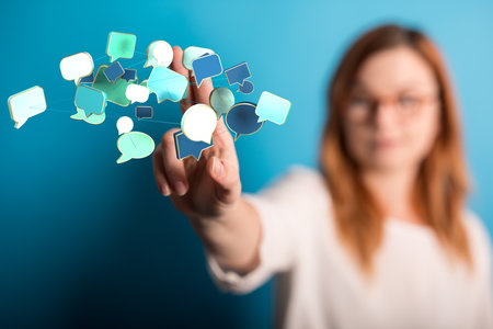 A businesswoman pointing to colorful communication speech bubble iconsの写真素材