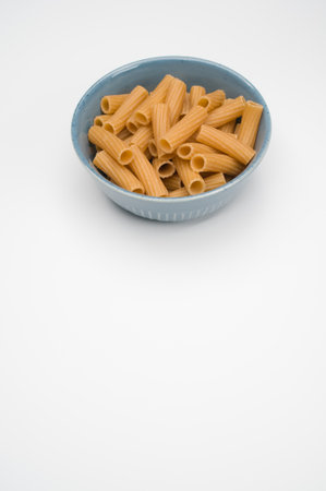 A vertical shot of rigatoni pasta on a bowl isolated on white backgroundの写真素材