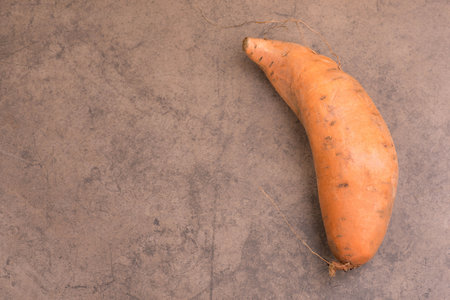 A closeup of a carrot on a brown surface.の写真素材