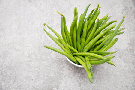 Fresh green string beans on a  textured background, empty space for text, vegetables, vegan food