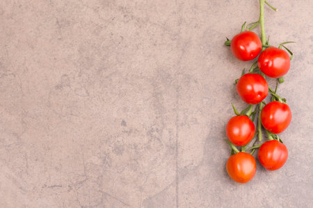 A closeup of red cherry tomatoes on a stone backgroundの写真素材