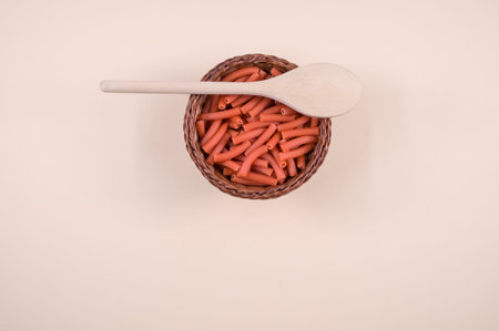 A closeup shot of macaroni with a spoon on a white background
