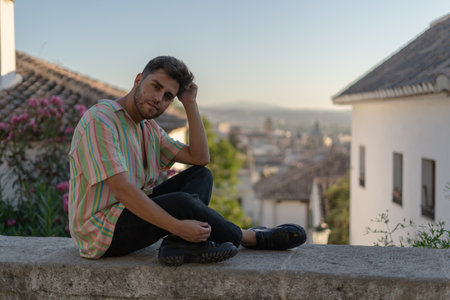 A handsome Caucasian guy wearing a striped shirt posing in the streetの写真素材