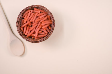 A top view shot of macaroni with a spoon on a white backgroundの写真素材