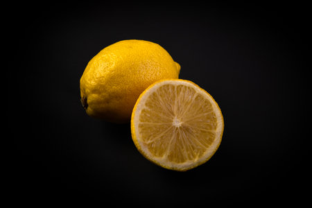 A closeup shot of lemons on a black backgroundの写真素材