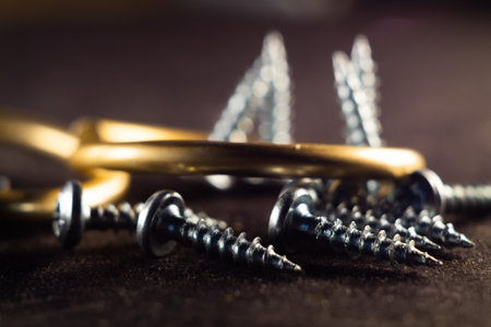 A closeup shot of stainless bolts and nails in a golden circle