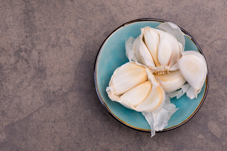 Fresh garlic on a textured brown background, spice, empty copy space for textの写真素材