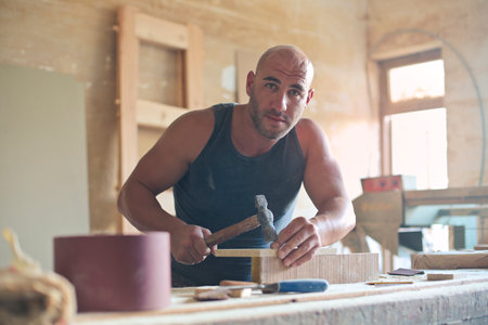An adult Hungarian carpenter working with the wood in the workshopの写真素材