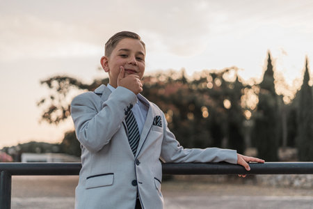 An adorable male child in a formal suit outfit posingの写真素材