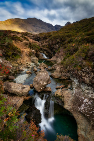 A vertical shot of waterfall on the River Coupall against Buachaille Etive Mor in Scotlandの写真素材