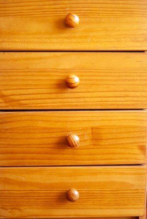 A closeup vertical shot of a wooden cupboard with handles