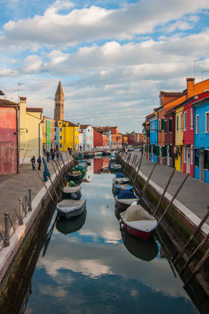 A beautiful view of boats and colorful buildings under a cloudy sky in the Burano island, Venice, Italyの写真素材