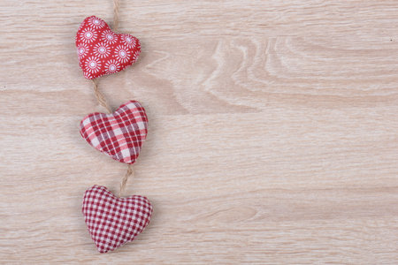 A top view of small heart-shaped cushions on a wooden surface with space for textの写真素材