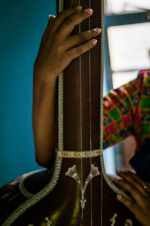 A middle-aged Indian woman holding an Indian musical instrument tanpura or sitarの写真素材