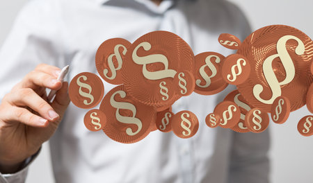 A closeup of floating 3D rendered justice symbols with a man pointing at them in the background.