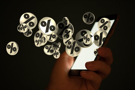 Floating 3D rate icons near a hand holding a smartphoneの写真素材