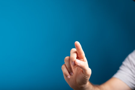 A closeup shot of a man's finger touching the screen and a blue background