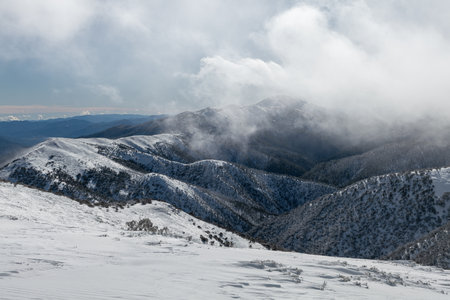 A beautiful winter scene in the mountains against a foggy skyの写真素材