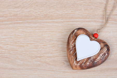 A heart-shaped necklace on a brown table surfaceの写真素材