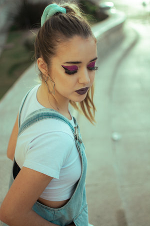 a high angle shot of hispanic young blond female with ponytail and bright makeup looking downの写真素材