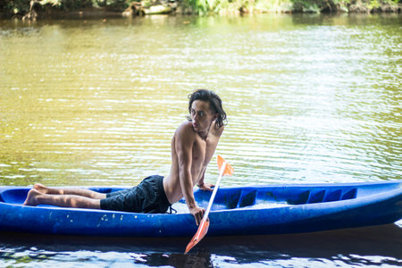 A scenic view of a Hispanic man kayaking on a lakeの写真素材