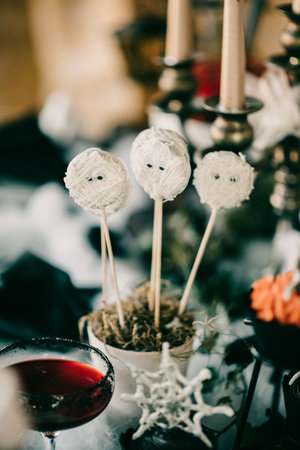 A vertical shot of spooky Halloween decorations, cookie pops decorated like mummysの写真素材