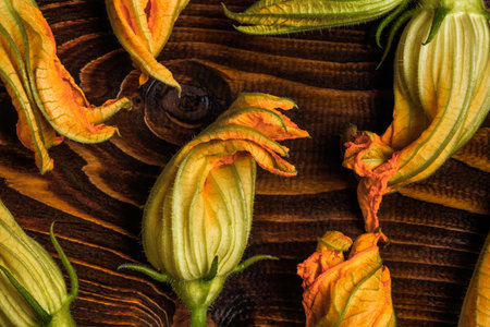 A directly above close-up of zucchini blossoms on a wooden backgroundの写真素材