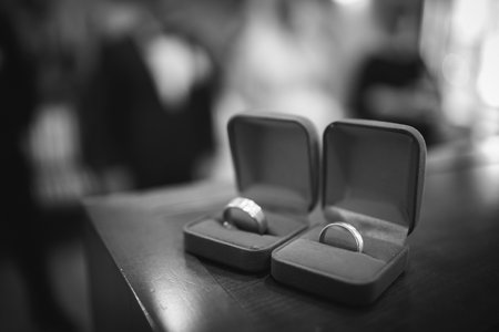 A grayscale shot of marriage rings during the ceremonyの写真素材