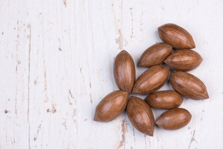 Pecan nuts on a shabby white background, empty copy space for text, pile of nuts