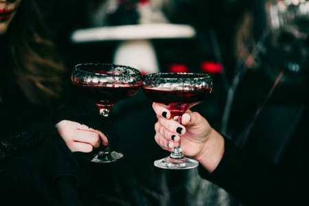 A spooky Halloween setting, two people drinking red cocktailsの写真素材