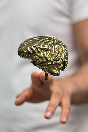 A vertical shot of a hand touching a floating 3D human brain icon aboveの写真素材