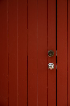 A dark red vintage door with silver handleの写真素材