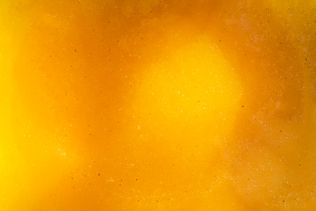 The golden textured surface of liquid bee honey with reflections of light. Delicious and healthy...