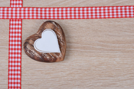 A heart-shaped ornament and tapes on the corner of a wooden surface for backgroundの写真素材