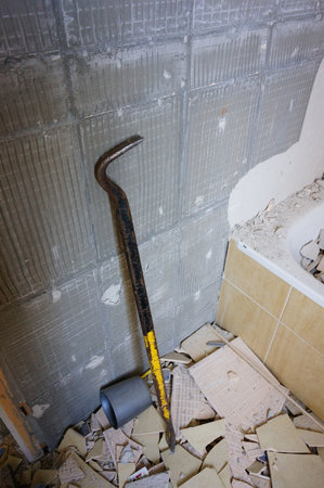 A vertical shot of an old crowbar in a disassembled bathroom