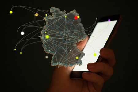 A closeup shot of a 3D rendering map of Germany coming out from a mobile phone on a dark backgroundの写真素材